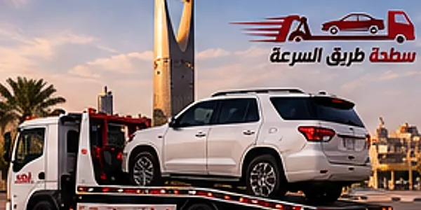 سطحة تحمل سيارة جيب بيضاء وخلفها برج المملكة في الرياض